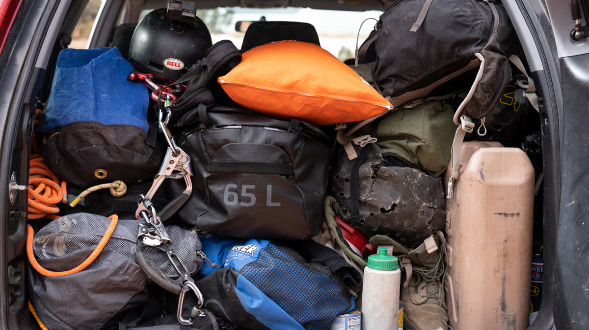 Several pieces of camping and hiking gear stowed in the back of an SUV.