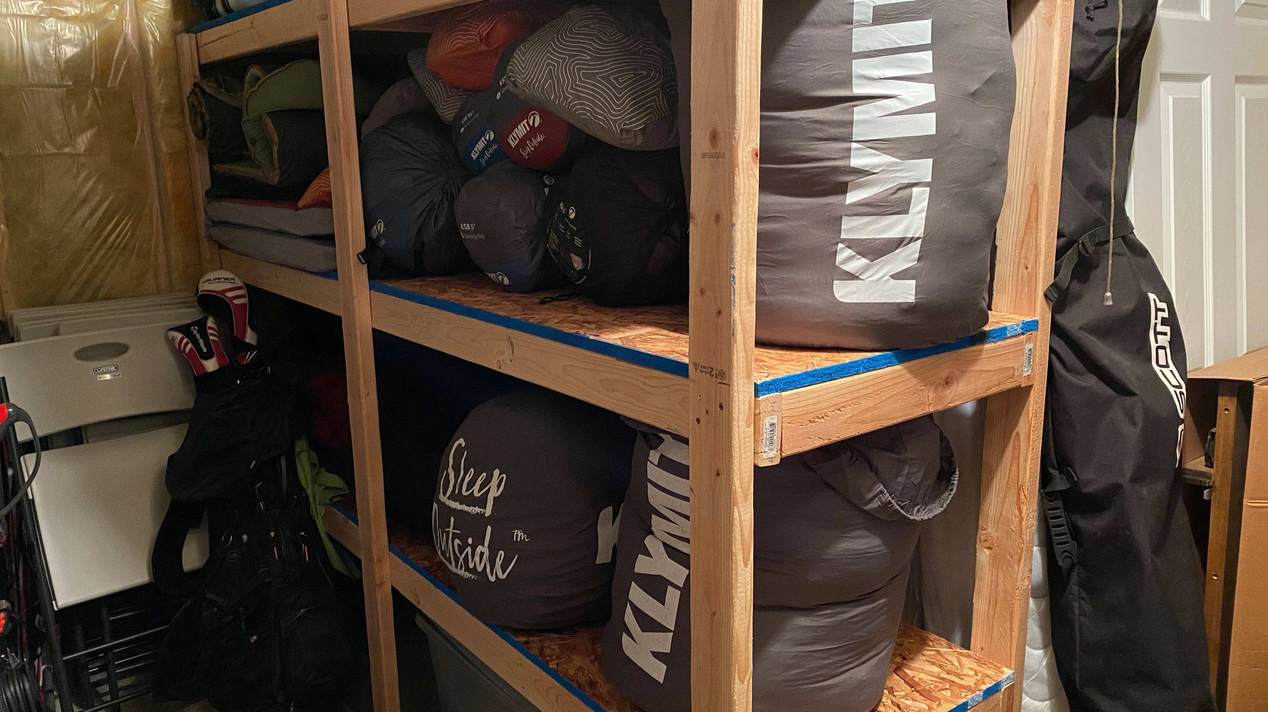 Camping gear stored on wooden shelves.