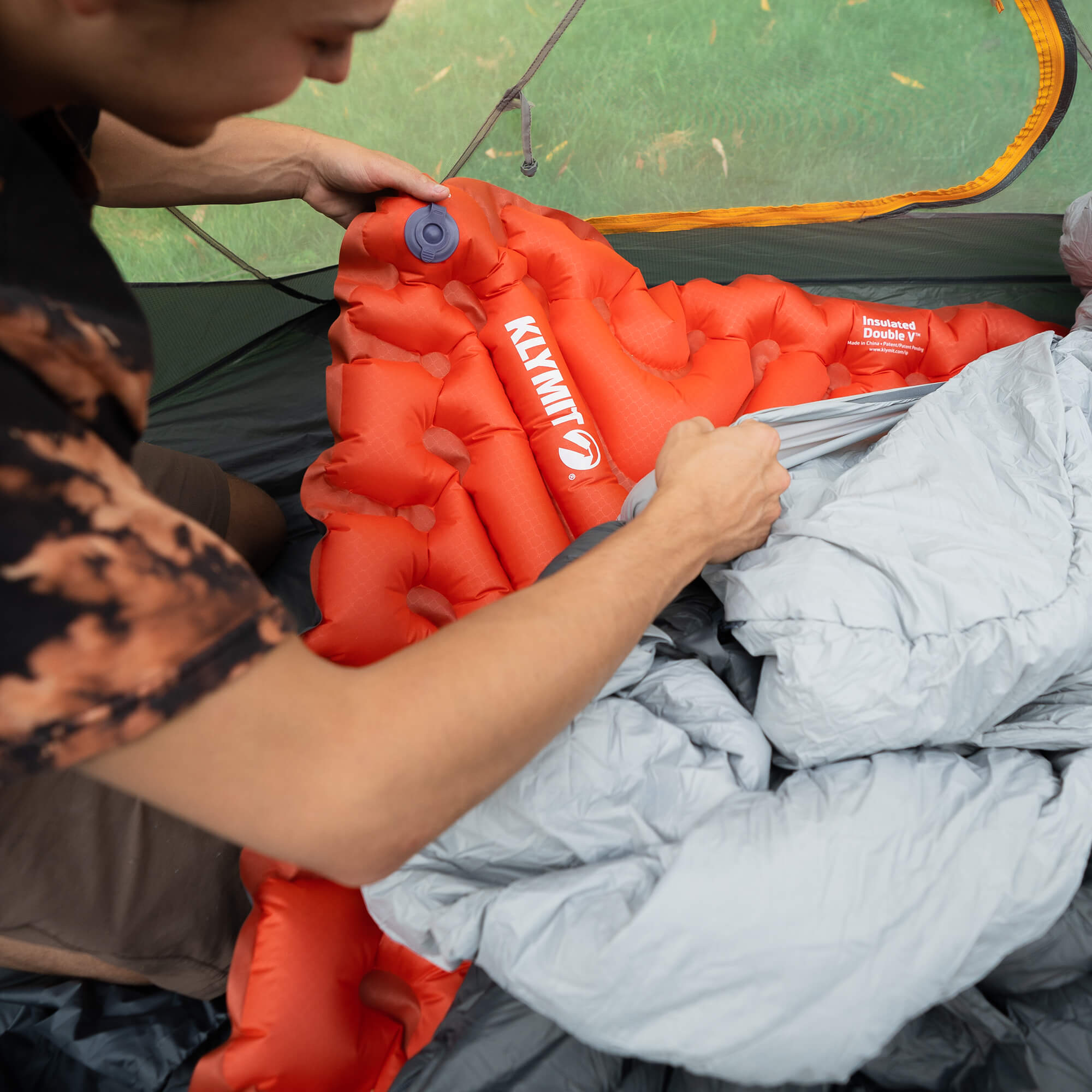 Insulated Double V Sleeping Pad, Orange, Lifestyle Placing the Pad in a Sleeping Bag
