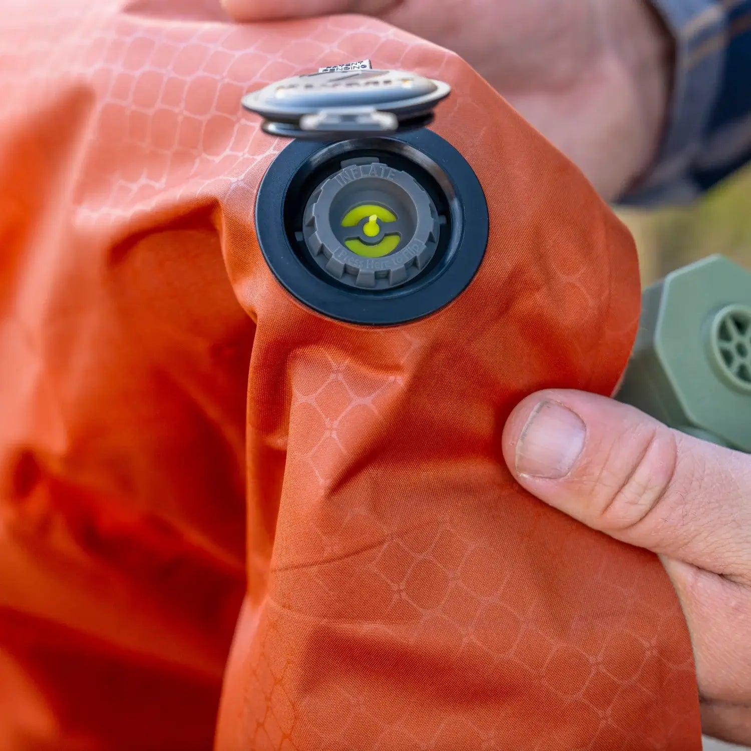 Close-up of the dual inflate and deflate valve system on a red rock Klymit Insulated Static V Peak XL sleeping pad.