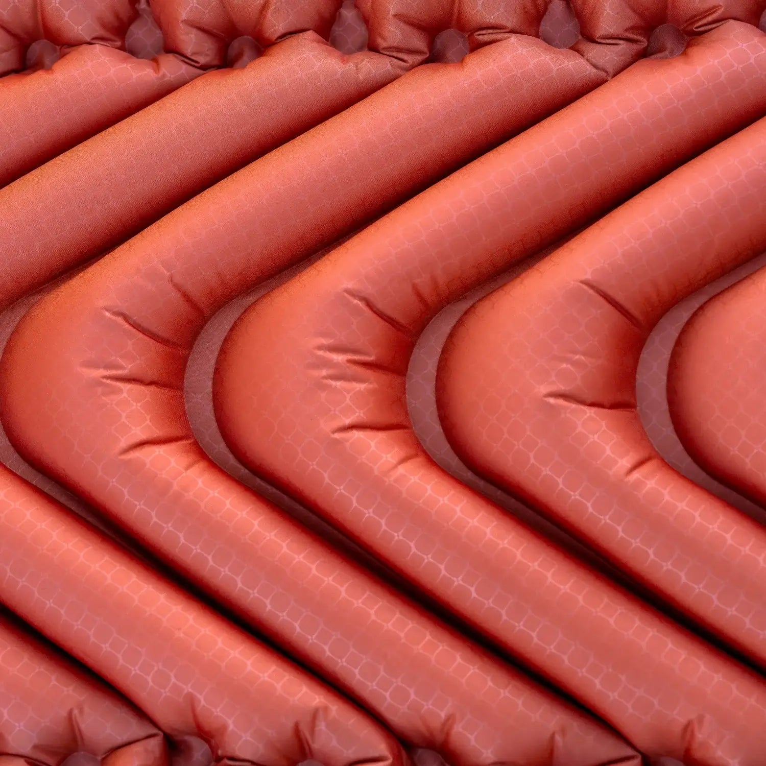 Detail shot of the red rock Klymit Insulated Static V Peak XL sleeping pad's V-shaped air chamber construction.