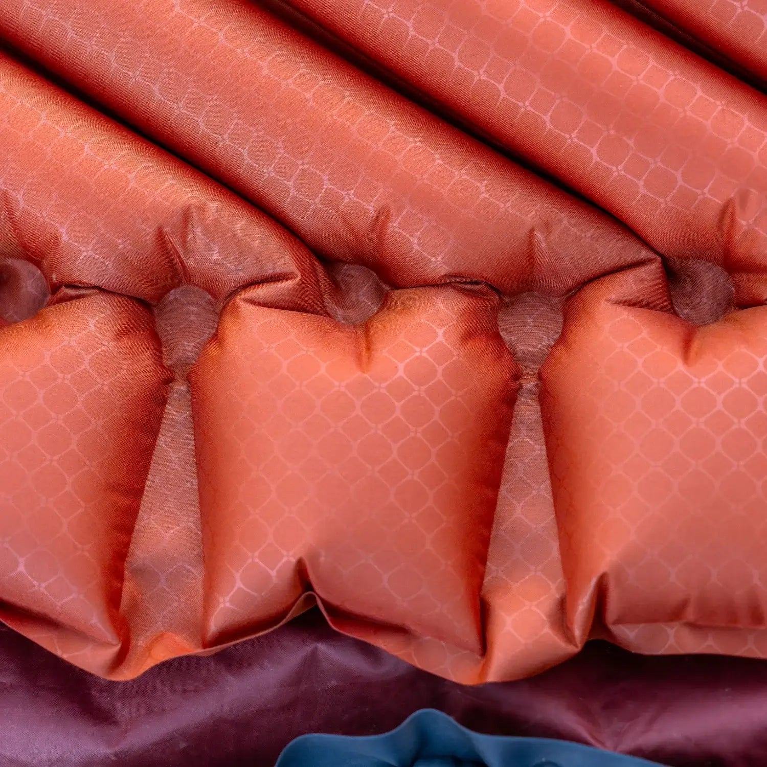 Detail shot of the red rock Klymit Insulated Static V Peak sleeping pad's V-shaped air chamber construction.