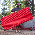 Insulated Static V Luxe Sleeping Pad, Red, Lifestyle Holding the Pad