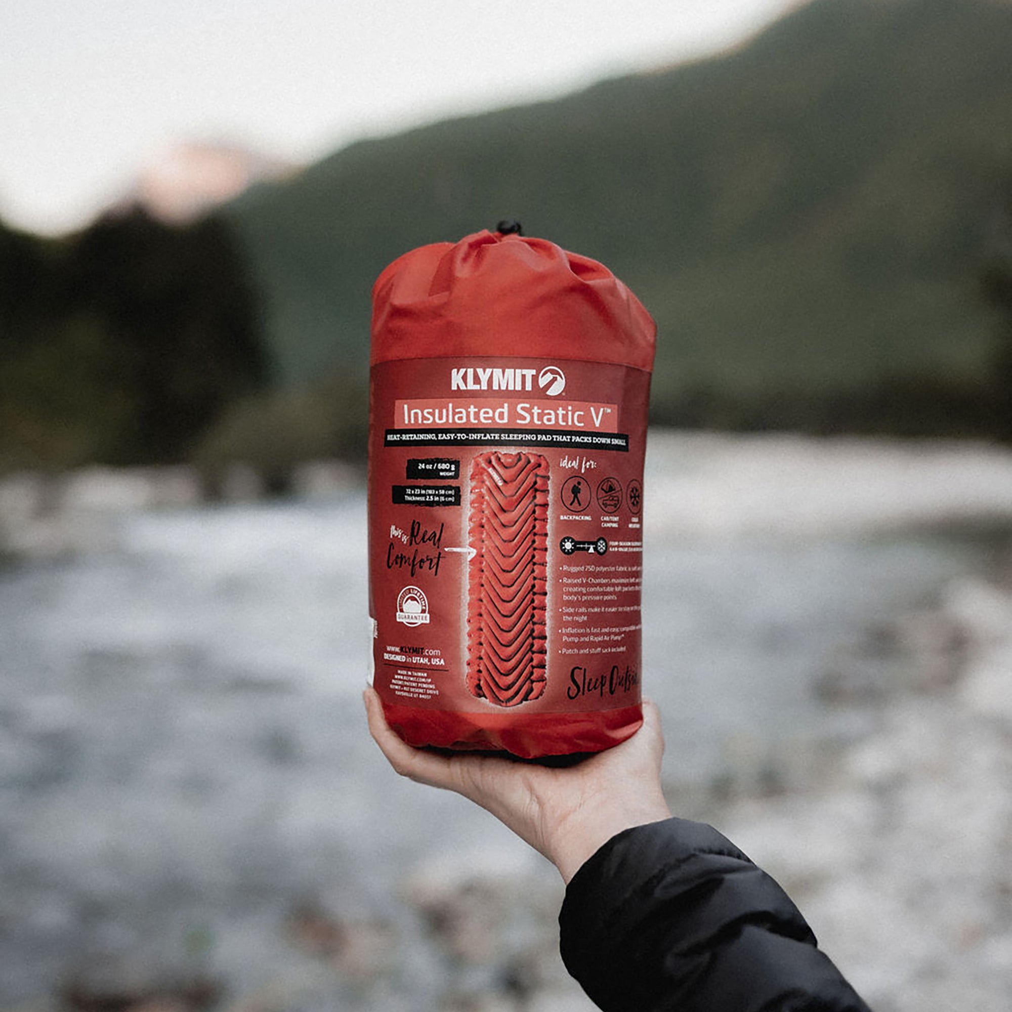 Insulated Static V Sleeping Pad, Orange, Lifestyle Holding the Stuff Sack