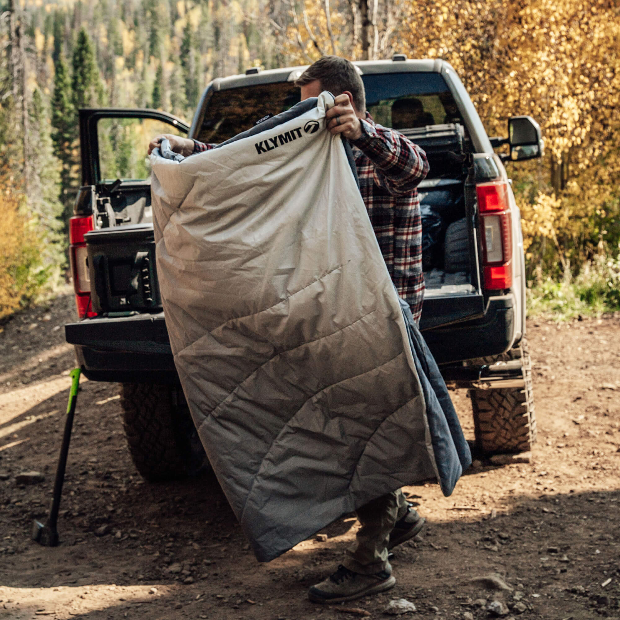 Horizon Overland Blanket, Gray, Lifestyle Man Folding the Blanket