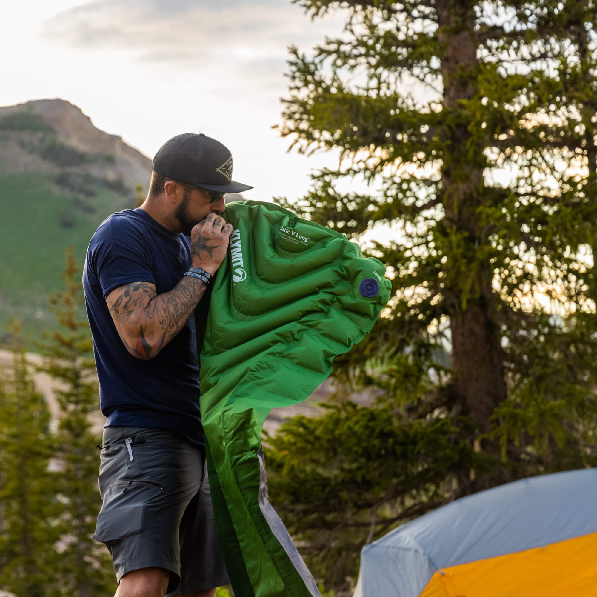Static V Long Sleeping Pad, Green, Lifestyle Man Inflating the Pad