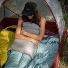 Wild Aspen 20 Degree Rectangle Sleeping Bag, Green, Lifestyle Woman Sitting on the Bag