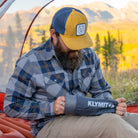 Man pulling out a Klymit Pillow X Luxe Summit from its sack inside a tent with a fall mountain view.