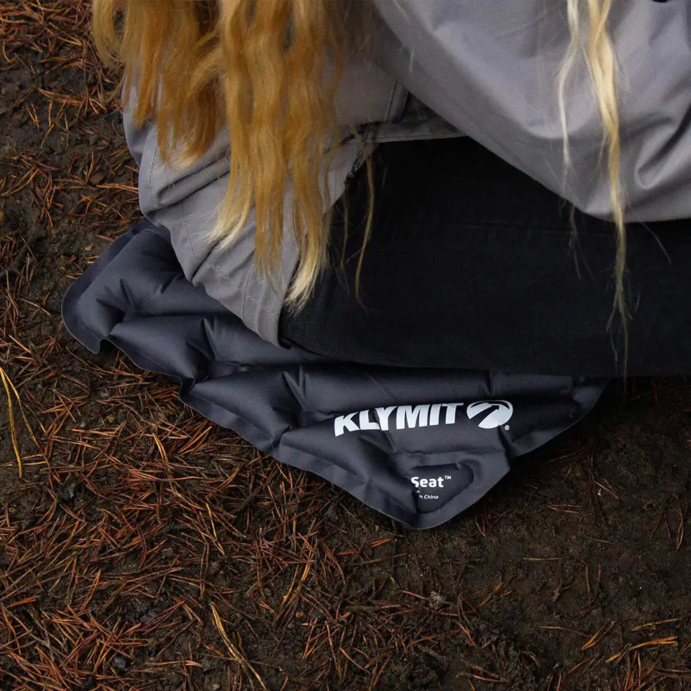 Person using a Klymit V Seat on the ground