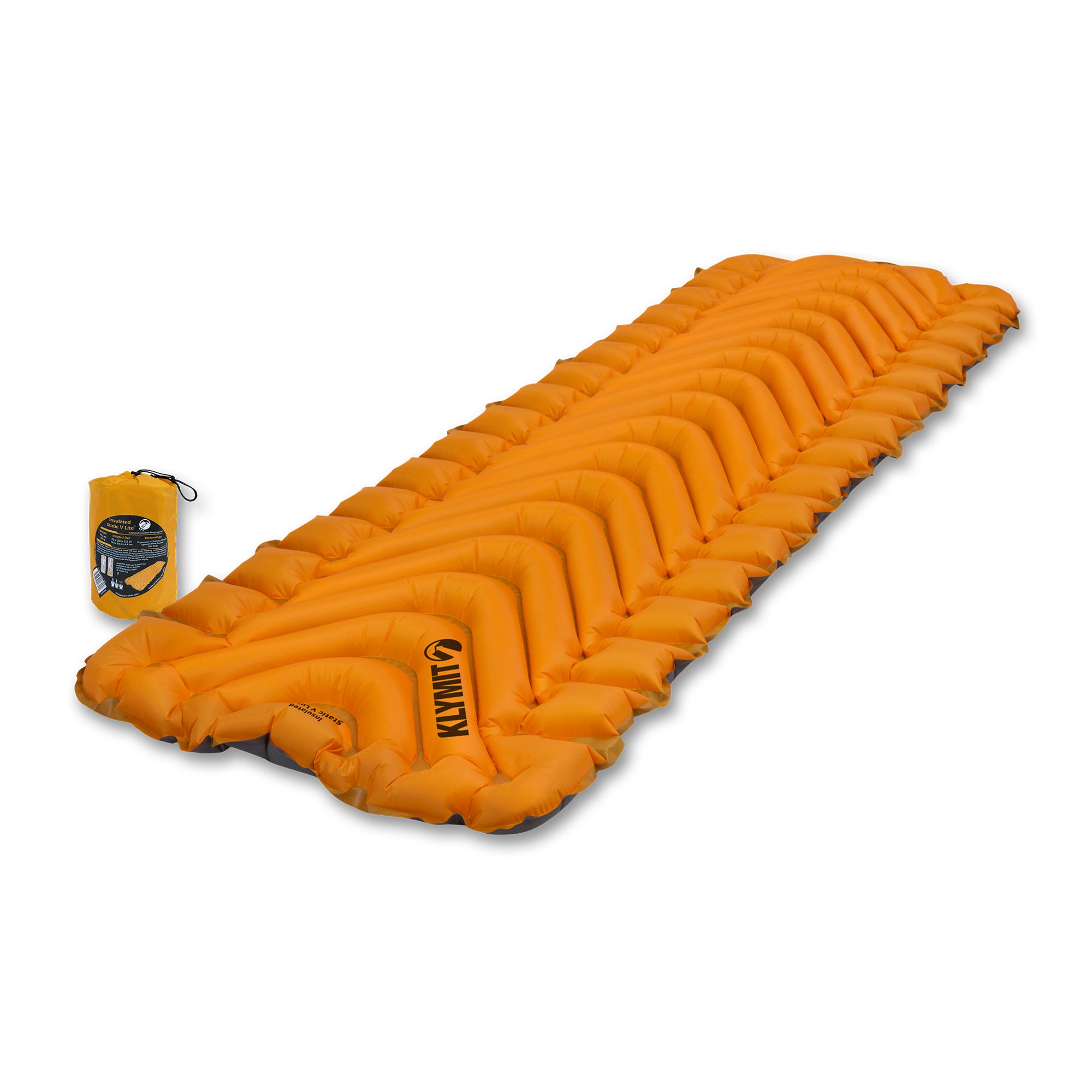 A rectangular orange inflatable Insulated Static V Lite sleeping pad with v shaped pattern shown at and angle on the ground with its stuff sack next to it.